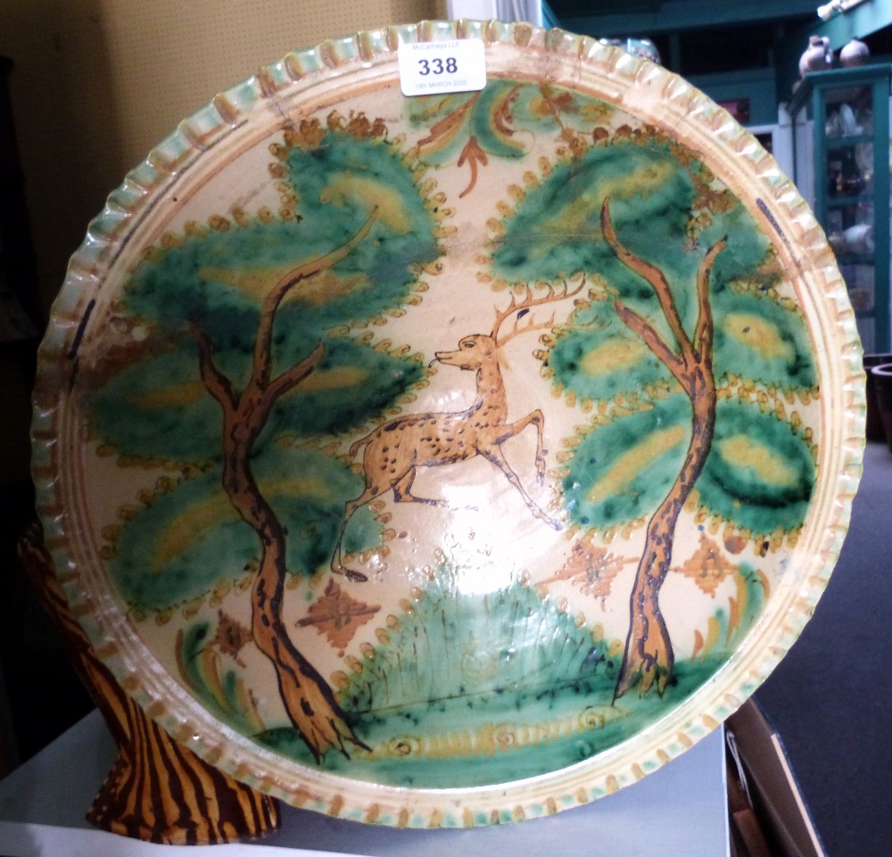 An early 19th century tin glazed charger of Talavera type, decorated with a stag among trees.