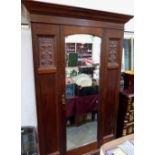 An Edward VII walnut wardrobe enclosed by a mirror door