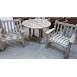 A teak garden table with two armchairs