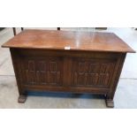 An oak chest with carved two panel front raised on trestle supports. 41' wide