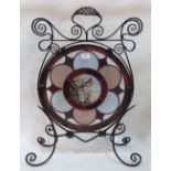 A Victorian wrought iron and stained glass firescreen, the centre pane painted with a bird in