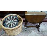 A dartboard, a dropleaf occasional table and a wicker log basket