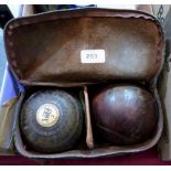 A pair of Victorian lignum lawn bowls in leather case