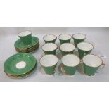 Ten green and foliate decorated coffee cups with eleven saucers. Early 20th century. One cup