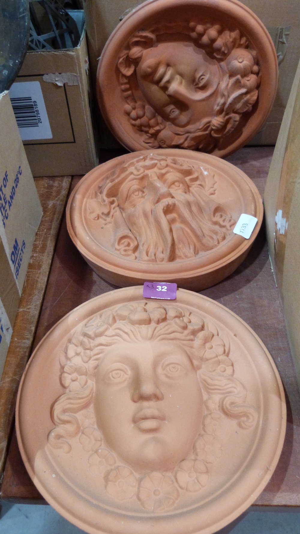 Two terracotta garden wall plaques