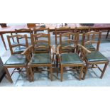 A set of eight joined oak dining chairs, each with a carved acorn to the stretcher, the set to