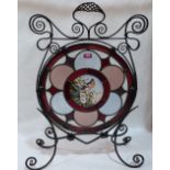 A Victorian wrought iron and stained glass firescreen, the centre pane painted with a bird in