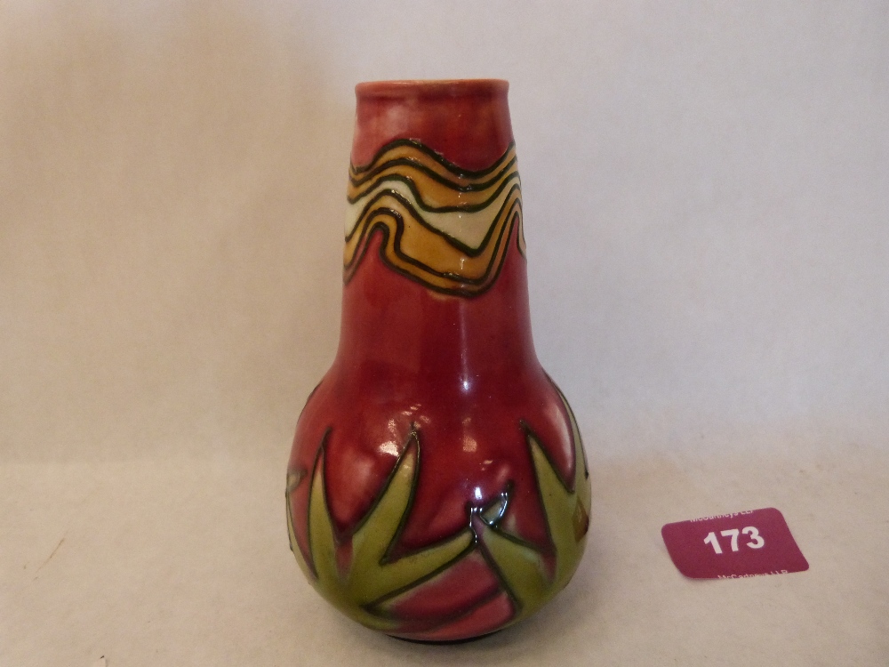 A Minton Secessionist vase, number 42, tube line decorated with foliage on a red ground. Factory,