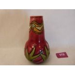 A Minton Secessionist vase, number 42, tube line decorated with foliage on a red ground. Factory,