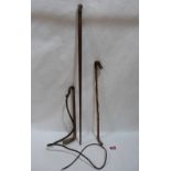 A walking cane with silver pommel, a riding crop and a whip