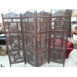 An eastern fret carved hardwood four-fold screen. 72' high x 85' wide