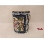 A Chinese blue and white porcelain mug, painted in coloured enamels with figures in a garden and