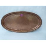 A Hugh Walker copper planished copper oval salver, the fold-over rim with traces of silvering.