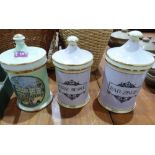 Three ceramic apothecary jars and covers, one decorated with a view of Buckingham Palace, the
