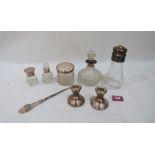 Four silver topped glass jars, a pair of silver squat candlesticks, a silver buttonhook and a silver