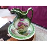 A Staffordshire washstand jug and bowl, transfer decorated with rose sprays on a green ground