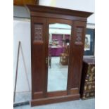 An Edward VII walnut wardrobe enclosed by a mirror door