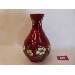 A Minton secessionist baluster vase, number 33; tube-line decorated with foliage on a blood red