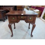 A Queen Anne walnut lowboy, the quartered top with re-entrant corners, crossbanding and line