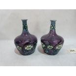 A pair of Minton Seccessionist vases, number 33, tube-line decorated with flowers on a purple