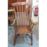 A Victorian high backed elbow chair on splayed turned legs