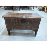 An early 17th century small oak six plank chest, the front scroll and diaper carved, the interior