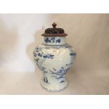 A Chinese inverted baluster blue and white jar with pierced treen cover, painted with figures in a