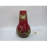 A Minton Seccessionist vase, number 42, tube line decorated with foliage on a red ground. Factory