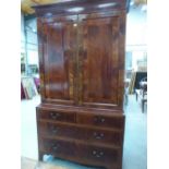 A George III mahogany linen press, the upper part enclosed by a pair of line inlaid and