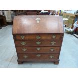 A George III oak writing bureau, the sloping fall over four long graduated drawers, on bracket feet.