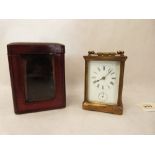 An early 20th century French brass carriage timepiece with alarm and leather travelling case. The