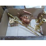 A Victorian copper kettle, a pair of brass candlesticks, a brass trivet and a pair of brass fire