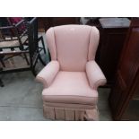 A pink wing armchair on cabriole legs