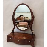 A George III mahogany dressing table mirror, the oval plate over a crossbanded serpentine base