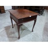 A George III mahogany dropleaf table, the hinged top enclosing a well, on scrolled cabriole legs.