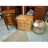 A pine three drawer bedside chest, a walnut pot cupboard and a leather pouffe