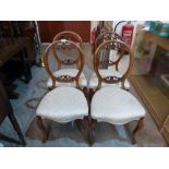 A set of four Victorian walnut balloon back salon chairs on cabriole legs