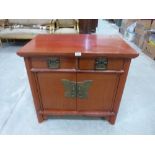 A Chinese lacquered cabinet enclosed by a pair of doors under a pair of frieze drawers. 31' wide