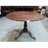 An antique mahogany snap-top supper table, the one piece pie-crust top on fluted and wrythen