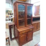 A Rhodesian mahogany bookcase enclosed by a pair of glazed doors over base with long drawer and