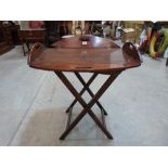 A 19th century mahogany drop-sided butler's serving tray on folding stand. (Loss to one drop-side)