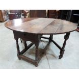 A 17th century joined oak dropleaf table, with two frieze drawers on baluster ring turned legs and