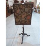 A 19th century mahogany polescreen with tapestry banner, on carved tripod support. 52' high