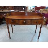 A George IV mahogany bow-breakfronted washstand, the galleried top over three frieze drawers on ring