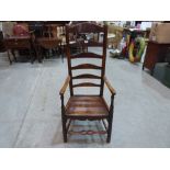 A 19th century oak clisset elbow chair with unusually high ladder back