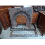 A Victorian cast iron fireplace insert and two iron fenders