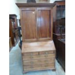 An 18th century walnut bureau bookcase, the upper part enclosed by a pair of panel doors, the base