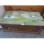 A painted chest, the lid decorated with a village scene. 33' wide