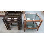 A nest of three bamboo and glass topped occasional tables and a two tier bamboo table
