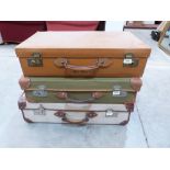 A vintage leather suitcase and two canvas cases